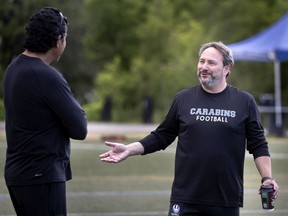 Université de Montréal Carabins head coach Marco Iadeluca chats with Anthony Calvillo during a conditioning session in Montreal on Thursday.