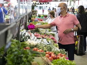 Jean-Claude Dopia buys his produce in the centre aisle of Jean-Talon Market on Saturday, June 27, 2020.