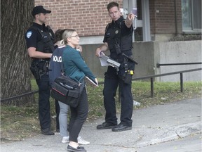 Montreal police officers look for clues along St-Martin St. in Little Burgundy on Sunday, June 28, 2020, following an overnight shooting that left three people injured, including a 13-year-old child.