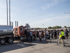 People react after a tanker truck drove into a crowd peacefully protesting the death of George Floyd on the I-35W bridge over the Mississippi River on May 31, 2020 in Minneapolis, Minnesota. A large group of protesters had been marching over the bridge on both lanes before a truck drove into the crowd.