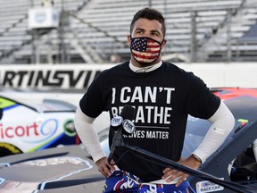 Bubba Wallace, driver of the #43 Richard Petty Motorsports Chevrolet, wears a "I Can't Breathe - Black Lives Matter" t-shirt under his fire suit in solidarity with protesters around the world taking to the streets after the death of George Floyd on May 25, speaks to the media prior to the NASCAR Cup Series Blue-Emu Maximum Pain Relief 500 at Martinsville Speedway on June 10, 2020 in Martinsville, Virginia.
