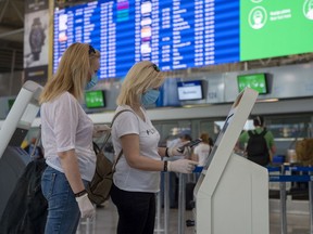 Passengers wear protective face masks and gloves as they check in for flights at Eleftherios Venizelos International Airport in Athens on June 15, 2020 in Athens, Greece. The country removed most restrictions on travel from EU countries today in an effort to jumpstart its tourist season. Travelers from countries deemed high-risk, like the UK countries, will still face compulsory Covid-19 testing and mandatory quarantine. One week for a negative result; two weeks for a positive result.