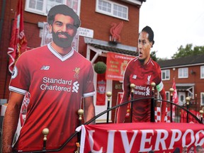 June 19, 2020: Cutout photos of Liverpool's Mohamed Salah, Virgil van Dijk and Liverpool manager Juergen Klopp (out of shot) are seen outside the house of Emily Farley, who has decorated it in memory of her husband David ahead of the return of the EPL.