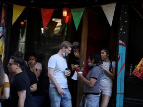 People drink outside a bar during the reopening phase following the COVID-19 outbreak in the East Village neighbourhood of New York City on Saturday, June 13, 2020.