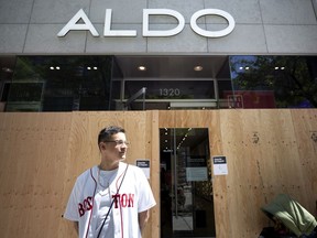 Aldo manager Marshall Banks surveys a small line outside the Ste-Catherine St. store in Montreal, on Saturday, June 6, 2020. Aldo was one of many shops that have boarded up their store fronts in advance of a march against police brutality.