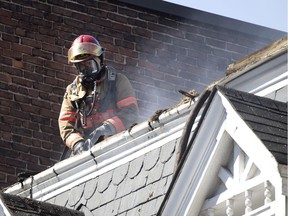 Montreal firefighters work on a four-alarm rooftop blaze that was started by cigarettes on June 11, 2020.