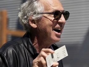 Gilles Ste-Croix, co-founder of the Cirque du Soleil, holds a ticket to the first show ever staged by the Cirque, as he speaks to artisans, directors, technicians and musicians as they stage a protest after the circus failed to pay them $1.5 million in back wages.