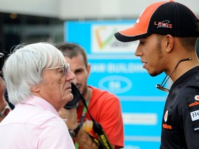 In this file photo taken on June 3, 2020, McLaren-Mercedes driver Lewis Hamilton of Britain, right, speaks with Formula One Management (FOM), Formula One Administration (FOA) and Formula One Constructors' Association (FOCA) president and CEO Bernie Ecclestone, left, at the paddock one day before the practice sessions of Formula One's Indian Grand Prix at the Buddh International circuit in Greater Noida.