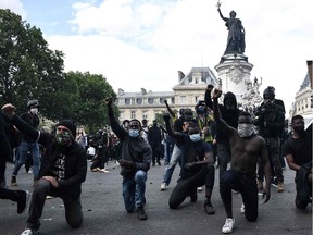 Men take to the knee during a rally as part of the Black Lives Matter worldwide protests against racism and police brutality on Place de la République in Paris on Saturday, June 13, 2020. A wave of global protests in the wake of American George Floyd's fatal arrest magnified attention on the 2016 death in French police custody of Adama Traore, a 24-year-old black man, and renewed controversy over claims of racism and brutality within the force.