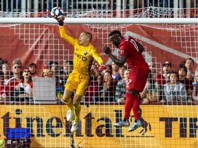 Montreal Impact goalkeeper Evan Bush makes a save against Toronto FC forward Jozy Altidore during the second half at Rogers Centre in Toronto on Aug. 18, 2019.