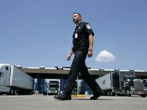 A U.S. Customs and Border Protection officer walks past a truck inspection station at the U.S. border in Buffalo, N.Y., on Tuesday, June 6, 2006.