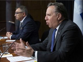 Quebec Premier François Legault, right, responds to question during a COVID-19 news briefing on June 11 in Quebec City while sitting beside Horacio Arruda, the director of public health.