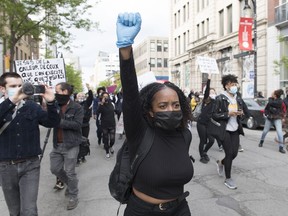 A woman raises her fist during a demonstration calling for justice for George Floyd in Montreal, Sunday, May 31, 2020. Graham Hughes/THE CANADIAN PRESS