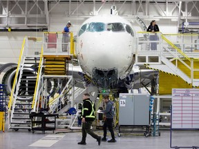 Employees work on an Airbus A220-300 at the Airbus facility in Mirabel in February 2020.