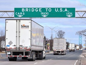Transport trucks approach the Canada/USA border crossing in Windsor, Ont. on Saturday, March 21, 2020. The federal NDP health critic says he is greatly concerned that there is no tracking of COVID-19 infections in long-haul truckers who are travelling back and forth across the United States border.THE CANADIAN PRESS/Rob Gurdebeke
