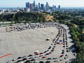 An aerial view of people in cars lined up to be tested for COVID-19 in a parking lot at Dodger Stadium on Friday, June 26, 2020, in Los Angeles.