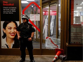 A member of the New York City Police Department stands outside a CVS store after it had be vandalized amid nationwide unrest following the death in Minneapolis police custody of George Floyd, in the midtown section of Manhattan on June 1, 2020.