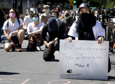 Protesters take a knee for a minute of silence during march against racism and policy brutality in Montreal on Sunday, June 7, 2020.