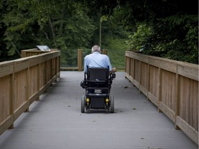 A man in a wheelchair uses a trail adapted for people with disabilities at a park in Kentucky. "We would all like to believe that cumulatively, small gestures will move us closer to an inclusive society," Laurence Parent writes, but this "does little to change the root causes of the barriers and discrimination."