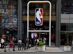 The NBA logo is displayed as people pass by the NBA Store in New York on Oct. 7, 2019.