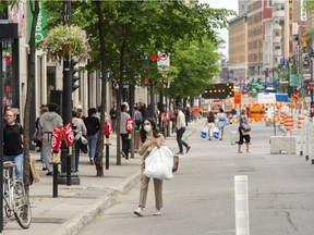People walk along a wide pedestrian walkway to facilitate social distancing because of the COVID-19 pandemic on Ste-Catherine St. on Tuesday, June 9, 2020, in Montreal.
