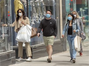 Despite the improving outlook, Montreal is still the provincial epicentre of the pandemic. Above: protective face masks are worn by pedestrians on Ste-Catherine St. on Tuesday, June 9, 2020.