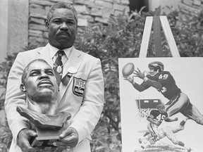 In this July 30, 1983, file photo, former Cleveland Browns and Washington Redskins halfback and wide receiver Bobby Mitchell poses with his bronze bust after being inducted into the Pro Football Hall of Fame in ceremonies in Canton, Ohio.    The Washington Redskins will retire the jersey of Mitchell and rename the lower level of FedEx Field for him, replacing former owner George Preston Marshall.  The team, which is being pressured to change its name during the ongoing national reckoning over racism, said Saturday, June 20, 2020,  that the No. 49 will become on the second in the franchise's 88-year history to be retired.