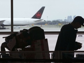 A passenger waits beside his luggage at the departure terminal at Pearson International Airport in Toronto, Friday, May 24, 2019. The federal government says it's extended tight rules on foreign travellers' entering Canada until the end of July, to keep COVID-19 from spreading.