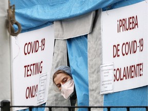A medical worker sticks her head outside a COVID-19 testing tent set up outside Elmhurst Hospital Center in New York, Saturday, March 28, 2020. The hospital has been caring for a high number of coronavirus patients. What happened in New York showed us how bad it could have been in Montreal, Christopher Labos says.