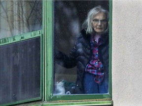 A resident waves from her window at Résidence Herron in Dorval, which was taken over by the local health authority after much of the staff fled.