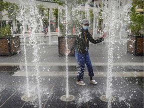 Julie Situ cools off in the fountain in Place des Festivals in Montreal Thursday July 2, 2020.