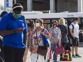 People line up for a bus at the Vendôme métro station in Montreal Monday, July 13, 2020. "Now that we're all wearing face coverings in an attempt to stop the spread of COVID-19 — not only that, but they are required by law in most indoor public spaces — it's hard not to wonder: what about the arguments that niqabs were problematic for public safety because they made it harder to identify the wearer?" Fariha-Naqvi-Mohamed asks.