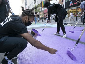 Kristian Clemens Alexandre adds the finishing touches to letter painted on St Catherine street near St Andre on Tuesday July 14, 2020. The sentence "La vie des noir.e.s compte" will be completed tomorrow by a group of young artist from the Montreal black community. (Pierre Obendrauf / MONTREAL GAZETTE)