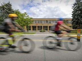 Cyclists ride past St-Monica's School on Terrebonne St. in Notre-Dame-de-Grâce. The borough intends to put a bike path on the street running in front of the school where school buses usually park.
