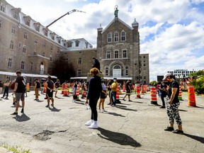 The line snakes through the parking lot for people waiting in line for COVID-19 testing at the former Hôtel-Dieu hospital in Montreal on Wednesday July 15, 2020.