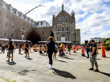 The line snakes through the parking lot for people waiting in line for COVID-19 testing at the former Hôtel-Dieu hospital in Montreal Wednesday July 15, 2020.