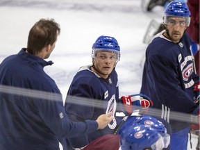 Canadiens defencemen Noah Juulsen (centre) and Josh Brook listen to assistant coach Luke Richardson during practice at the Bell Sports Complex in Brossard on Wednesday.