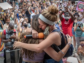 Camila Vasquez, right, hugs her sister Mariana Vasquez in front of the Montreal courthouse on Sunday after they told fellow marchers about being sexually abused by a family friend.