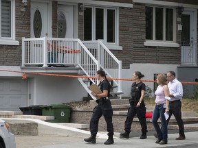 Police officers investigate outside home in east end Montreal on Friday where a 6-year-old girl was found suffering from stab wounds on Thursday and later died in hospital. Her mother is being held as a "material witness."