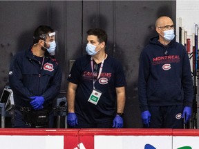 From left to right, Matthew Romano (assistant athletic therapist and physiotherapist), Patrick Langlois (assistant equipment manager) and Pierre Ouellette (assistant equipment manager) watch the Canadiens practise Thursday at the Bell Sports Complex in Brossard.