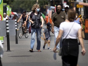 People enjoy the pedestrian walkway created on Wellington St. in Montreal on Friday, July 24, 2020.