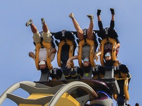 Masked people take a ride called the Vampire at La Ronde in Montreal on Saturday, July 25, 2020.