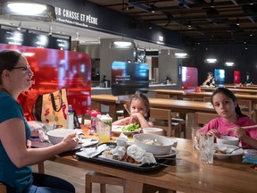 Nathalie Goudreau enjoys a little lunch with her daughters Simone, 5, and Jeanne, 8, at the Time Out Market in Montreal's Eaton Centre.