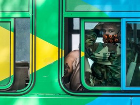 A man in camouflage and mask blends into a colourful STM bus on Tuesday, July 28, 2020. Dave Sidaway / Montreal Gazette ORG XMIT: 64793