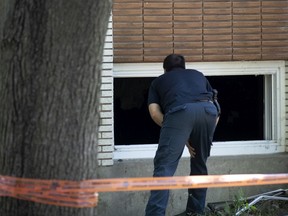 Montreal arson investigators examine the scene of Tuesday's fire on Marroni St. in LaSalle. While the cause of the fire remains unknown, the arson squad is involved because the incident resulted in a death.