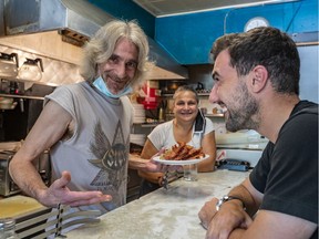 David Minicucci, the new owner of Cosmos, is served one last time by now previous owners Nikos Koulakis and sister Niki Koulakis at the restaurant in Montreal on Friday July 31, 2020.