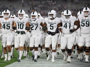 TEMPE, AZ - SEPTEMBER 08:  The Michigan State Spartans walk arm in arm onto the field before the college football game against the Arizona State Sun Devils at Sun Devil Stadium on September 8, 2018 in Tempe, Arizona.