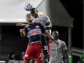 Brandon Bye of the New England Revolution and Romell Quioto, top, of Montreal Impact fight for a header during the second half in the MLS is Back Tournament at ESPN Wide World of Sports Complex on July 9, 2020, in Reunion, Fla.