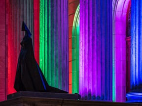 The bronze statue, Cloaked Figure IX by Lynn Chadwick amid rainbow colours on the columns at the Montreal Museum of Fine Arts on Thursday April 16, 2020.