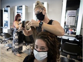 Hairdresser Isabelle Lachance at Salon Oblic in Ahuntsic is back at work cutting clients' hair. Instruments, chairs and surfaces are being thoroughly disinfected between appointments at hair salons across Montreal.